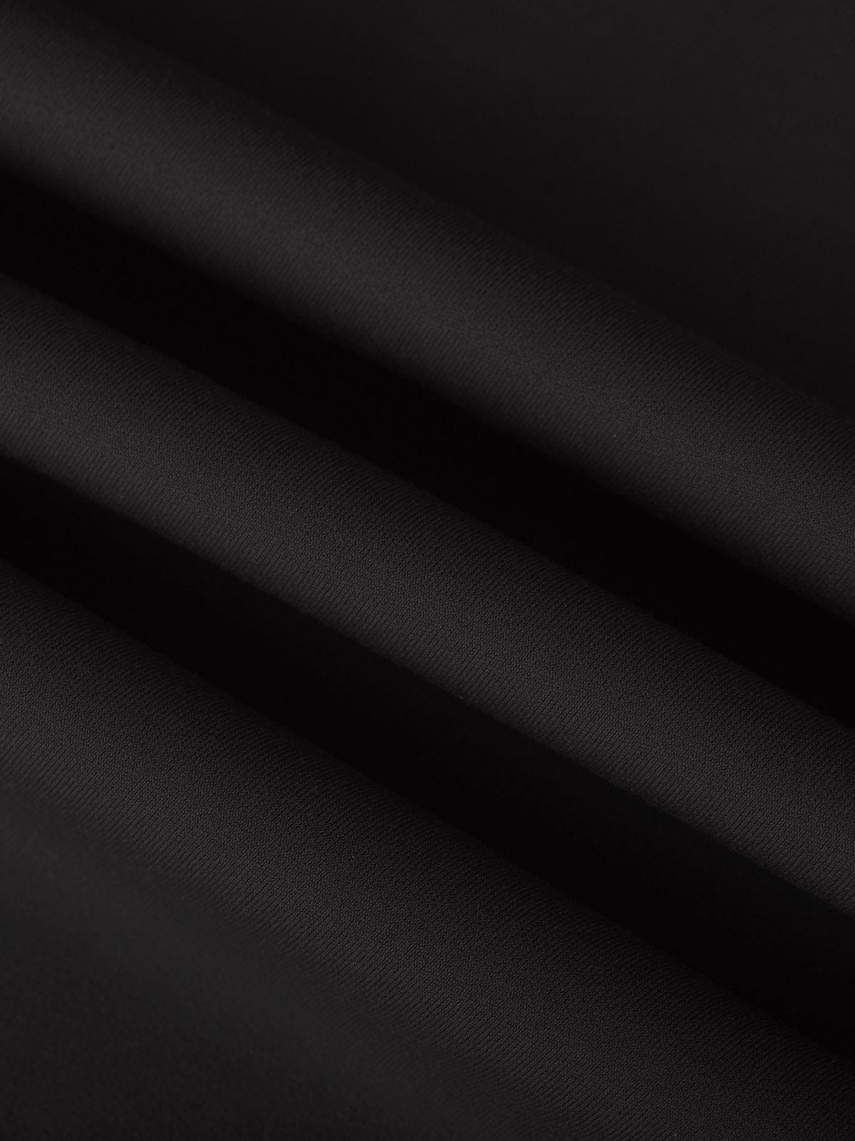 Close-up of the smooth, high-stretch Standard Black performance fabric on Vractive tennis dress