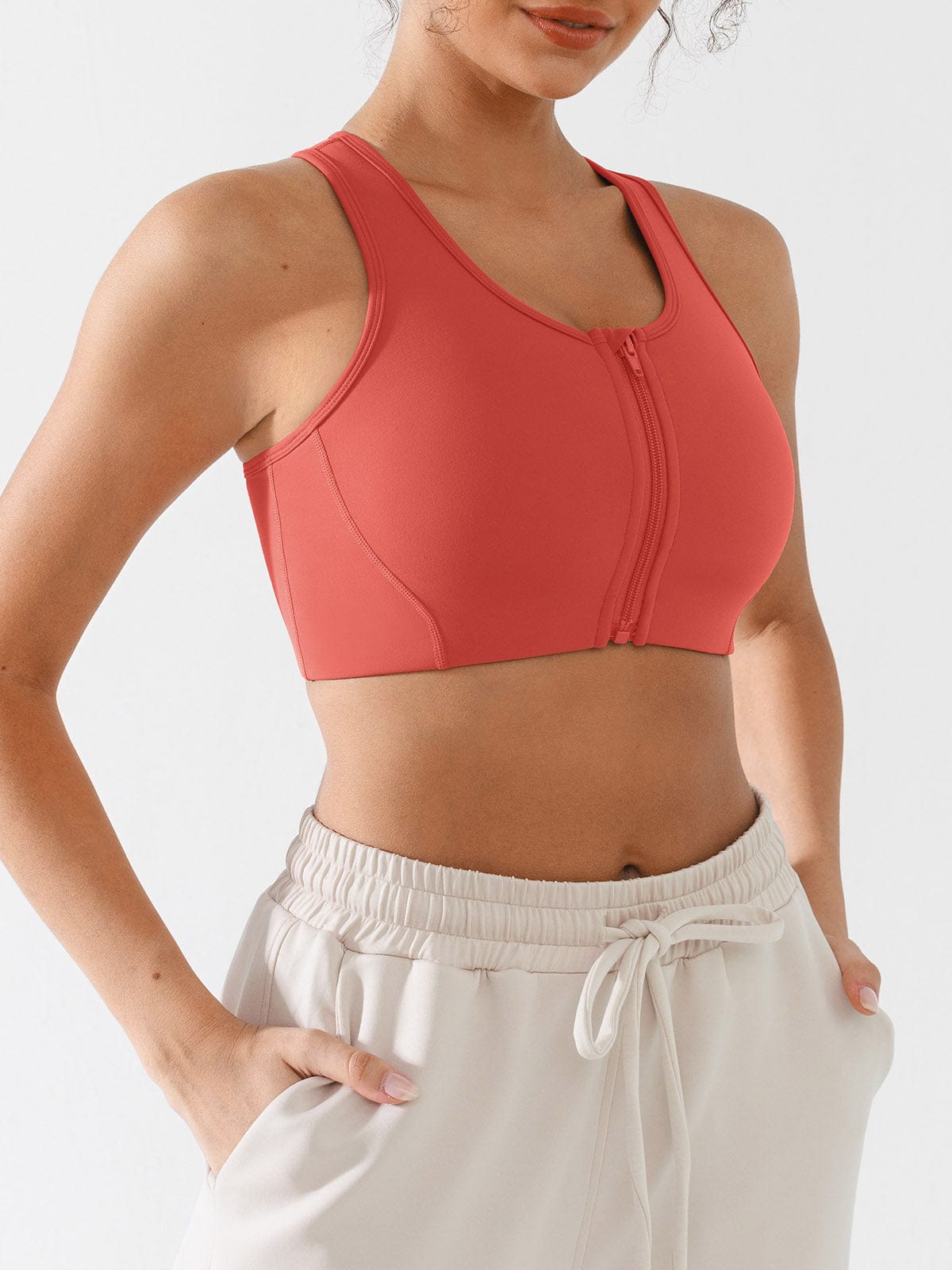 Profile view of woman in Mineral Red front-zipper sports bra by Vractive