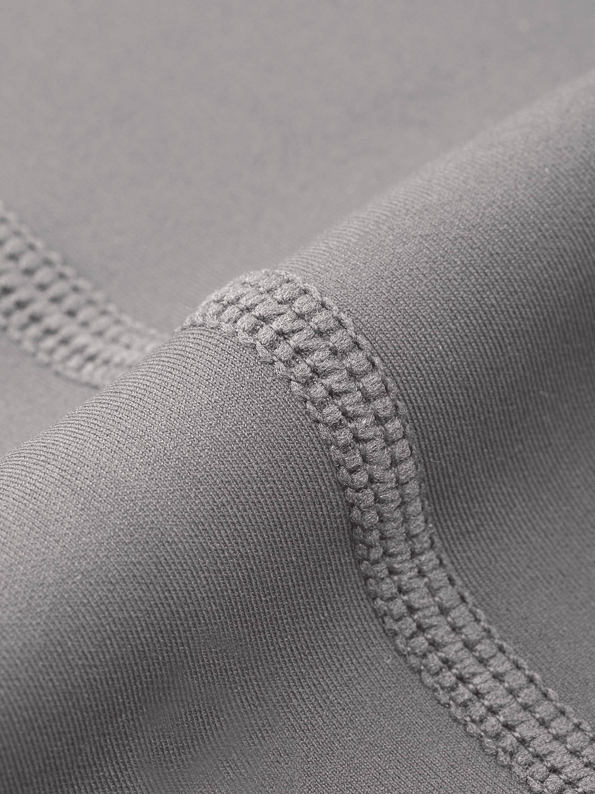 Macro view of durable anti-chafe stitching on Lead Gray Vractive gym leggings ensuring high quality