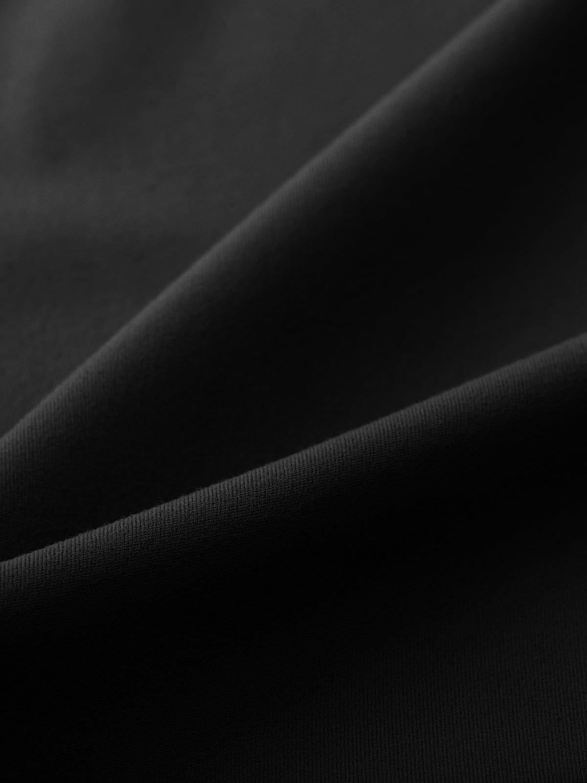 Macro view of the opaque, sweat-wicking Standard Black stretch fabric on Vractive flared leggings